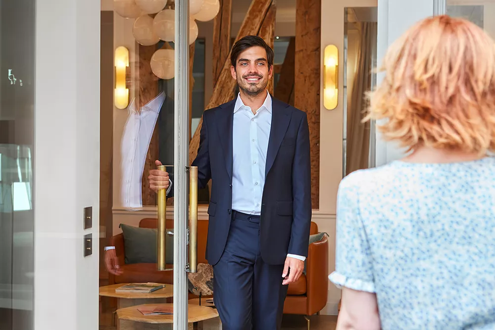 A Junot Fine Properties employee welcoming a client to the agency