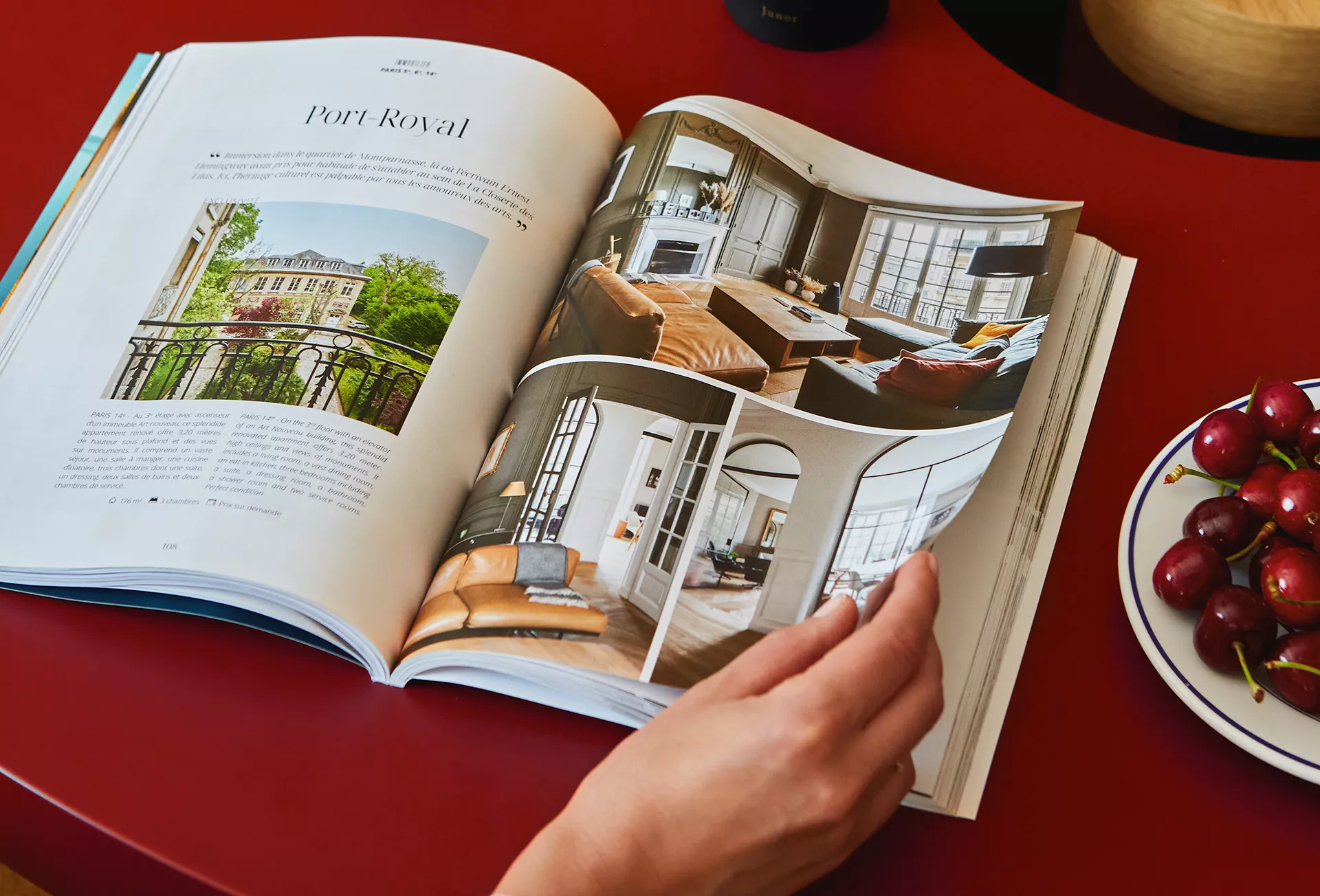 Person leafing through the Junot magazine on a red table
